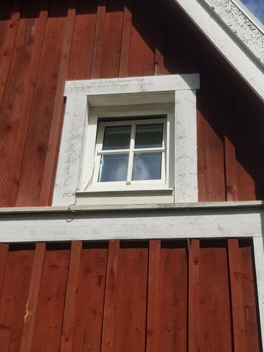 Accesspunkt monterad under takfot på hus med synlig nätverkskabel längs väggen.