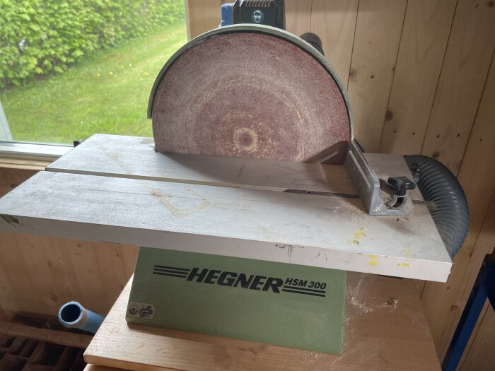 Bandslipmaskin från Hegner HSM 300 på ett arbetsbord med dammutsug.