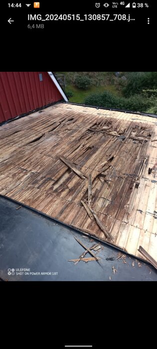 Fuktskada på träkonstruktionen under borttagen plåt på ett hus tak, med tydliga skador över köket.