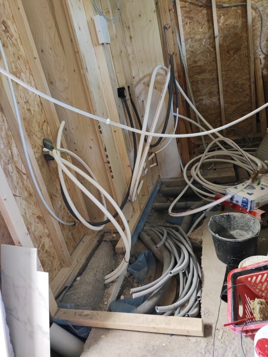 Pågående installation med rör och kablar i en ombyggnadsfas i ett byggrum.