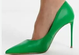 En grön högklackad sko på en persons fot.