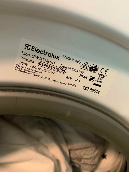 Typskylt på en Electrolux UWF47K8141 tvättmaskin med modell- och produktinformation.