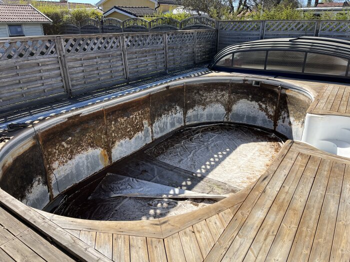 Renoveringsprocess av en gammal rostig pool med påbörjad installation av ny liner och konstgräs i botten.