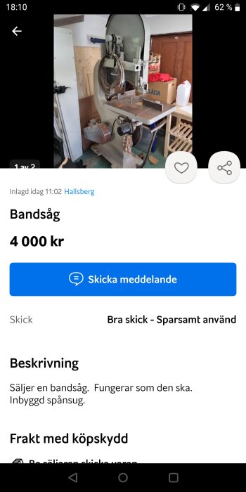 En bandsåg i ett verkstadsutrymme med tillbehör och en kartong i bakgrunden.