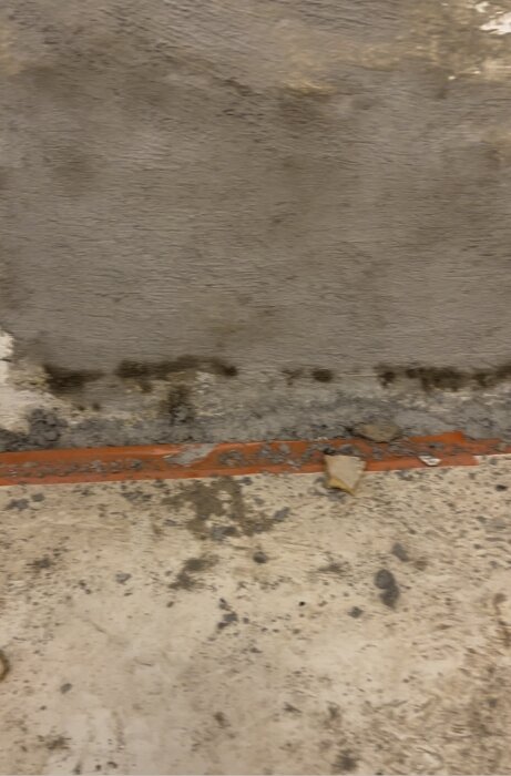 Smalt metallrör längs fuktig vägg i en renoverad källare, potentiellt med kallvattenflöde.