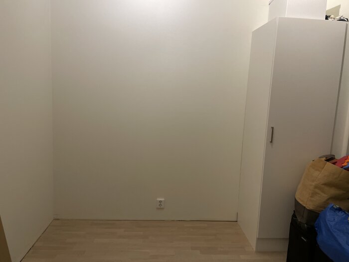Nybyggd garderobsvägg i MDF med IKEA stommar i ett rum med snedtak och trägolv.
