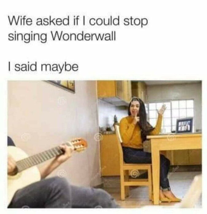 Kvinna pratar med man som spelar gitarr i ett vardagsrum, meme-text hänvisar till låten Wonderwall.