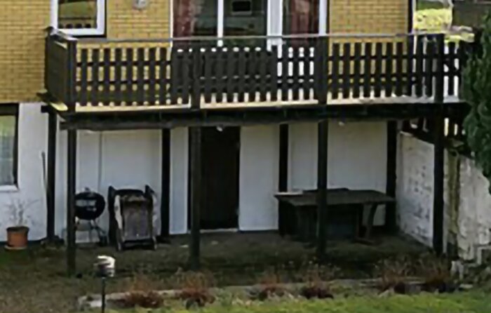 Bild på en befintlig balkong på 6x2,5 m, stödd av åtta plintar och bultade balkskor i en tegelfasad.