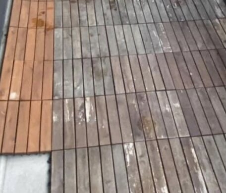 Obehandlade och delvis missfärgade träplattor på en balkong, jämförelse mellan rena och smutsiga ytor.