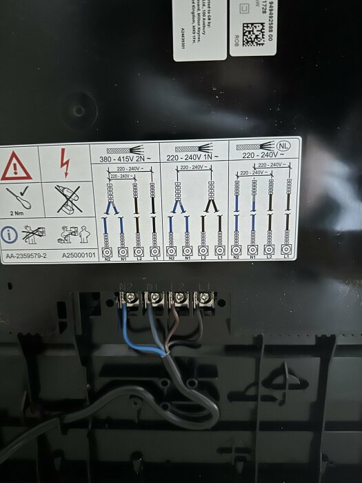 Elanslutningar och installationsinstruktioner på baksidan av en induktionshäll.