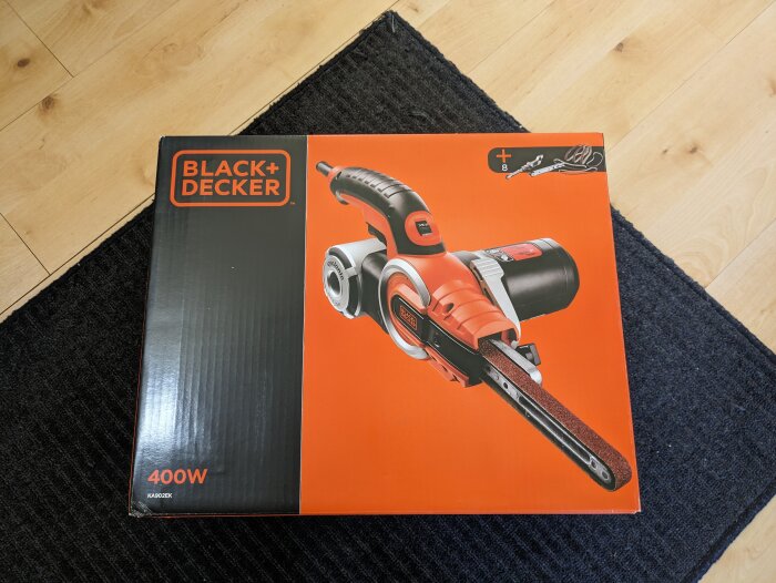 Ny Black & Decker 400W elslipmaskin i förpackning på ett golv, tänkt för fönsterrenoveringsprojekt.