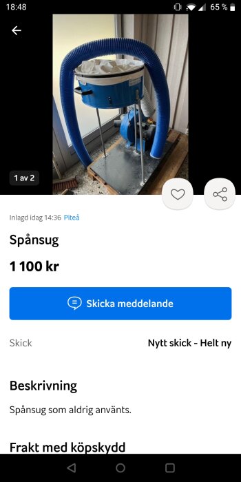 Blå spånsugsmaskin, oanvänd, med filter och böjliga slangar, i ett garage.