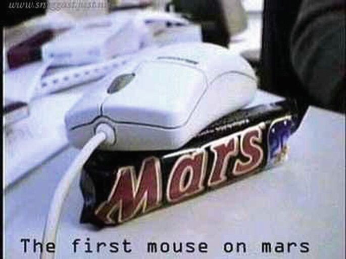 Dator mus vilar på en Mars chokladkaka med texten "The first mouse on mars".