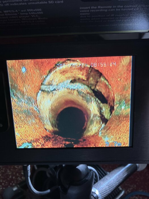 Inspektionsbild av skada i lergodsavloppsrör visad på skärm, djupet 3,7m anges.