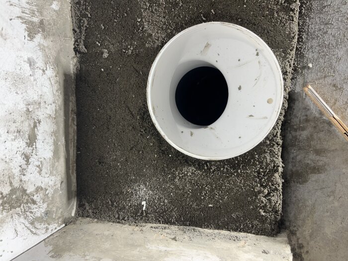 WC-avloppsrör omgivet av nygjuten betong med otillräckligt överlagringstjocklek.