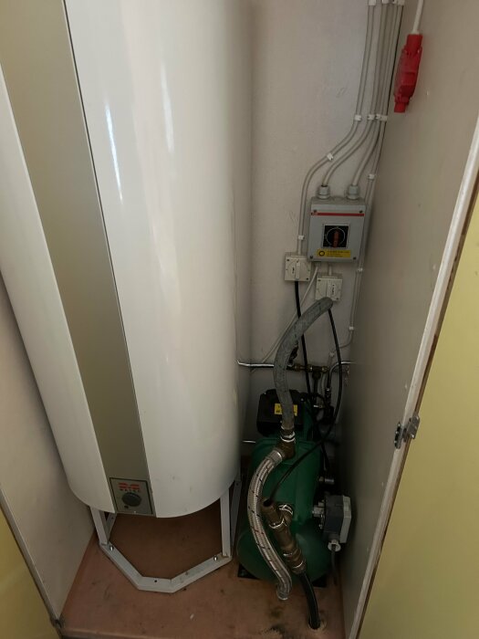 Varmvattenberedare och grön hydropress med en EMS Maxi Jet pump i ett pannrum.