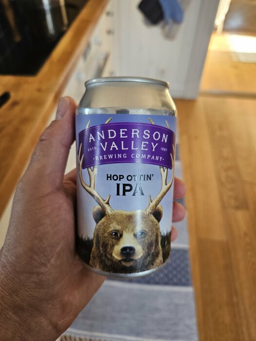 Hand håller en ölburk från Anderson Valley Brewing Company med björnmotiv och texten "Hop Ottin' IPA".