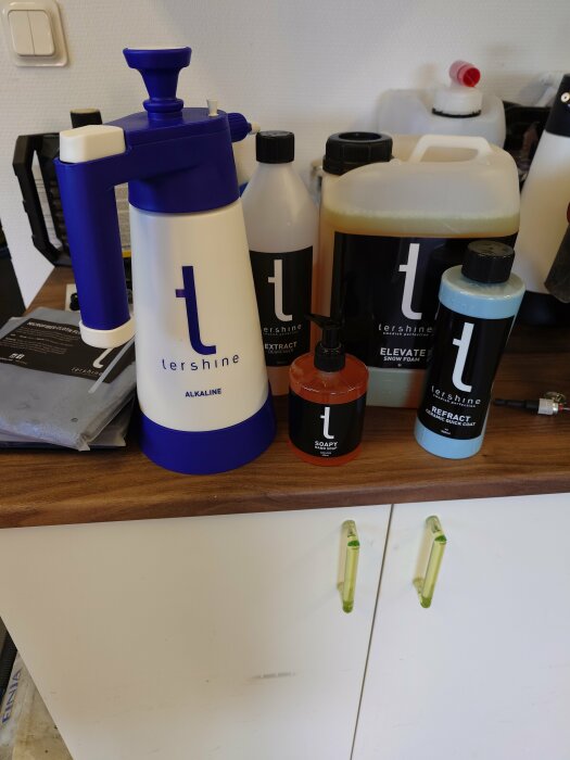En samling bilvårdsprodukter från märket Tershine, inklusive flaskor och behållare på ett bord.
