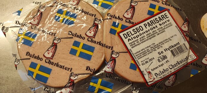 Två förpackningar av Delsbo parisare korv med svenska flaggor och logotyp.