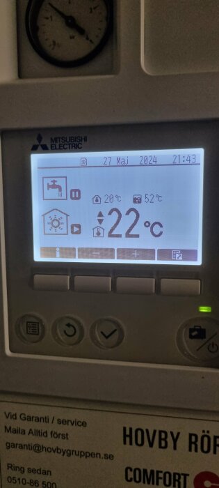 Värmepumpens display visar temperatur och inställningar, varumärke Mitsubishi Electric.