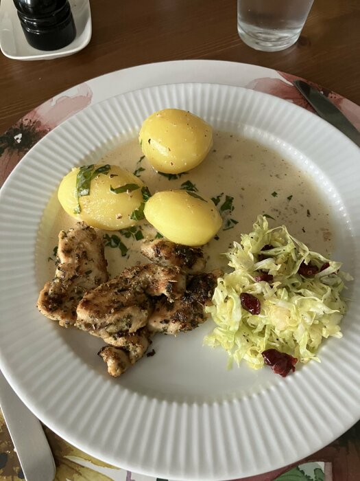 Tallrik med krÀmig basilikakyckling, kokt potatis, spetskÄl med tranbÀr/Àpple och sÄs.