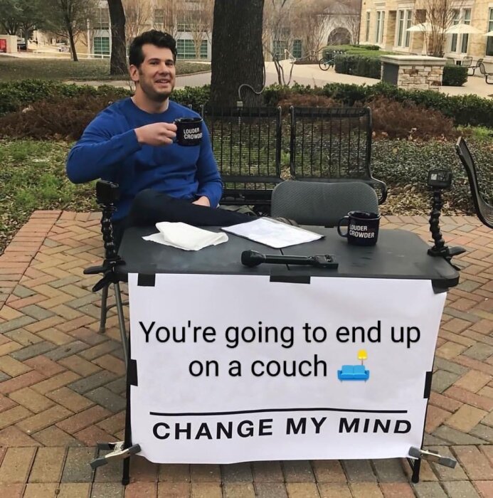 Person sitter vid bord med skylt som säger "You're going to end up on a couch 🛋 CHANGE MY MIND