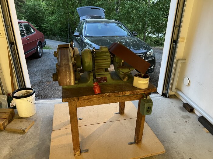 En Stenbergs skiv- och bandputs från 60-talet på en träbänk i ett garage med en bil i bakgrunden.