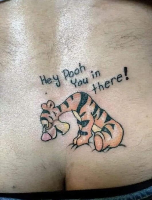 Tatuering av Tigger som tittar in i en navel med texten "Hey Pooh, you in there!