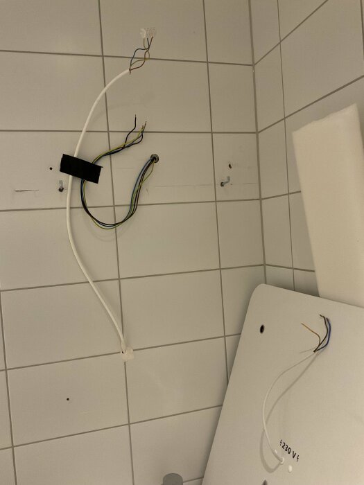 Elkablar ur en vägg och från en LED-spegel i badrummet, okopplade och redo för installation.