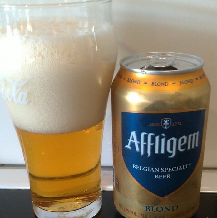 Affligem Blond belgiskt öl i glas och burk, med tydlig skumkrona.