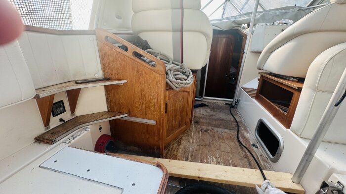Renovering av motorbåtens inredning med gammal träpanel och slitna sittdynor som ska uppgraderas.