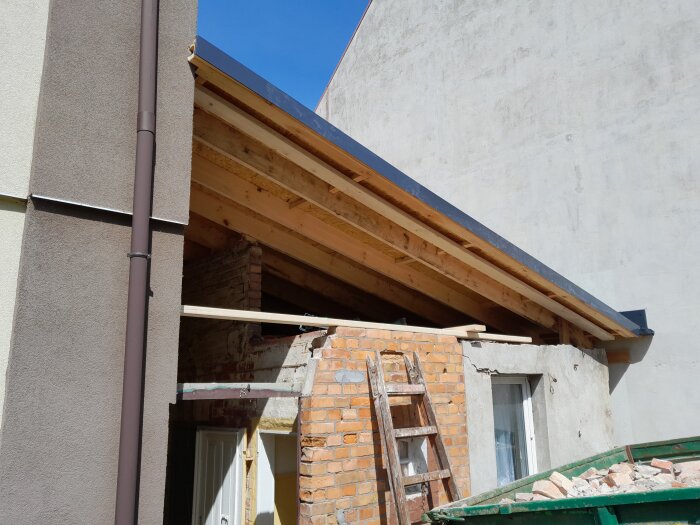 Renoveringsarbete på taket och väggar med ny takkonstruktion och synliga trätakbjälkar.