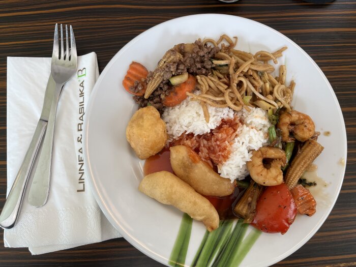 Tallrik med thaibuffé innehåller bland annat ris, friterad kyckling, räkor och grönsaker, serverad på restaurang L&B.