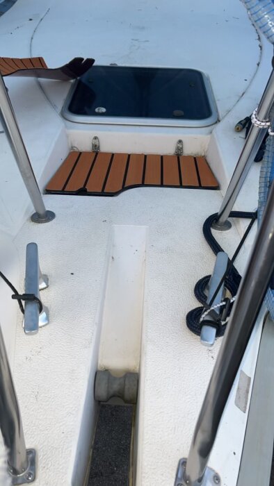 Trädäck i en båt med ny plexilucka klädd i vinylteak och omgivande rostfria detaljer.