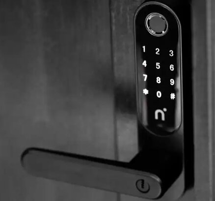 Kodlås installerat på en mörk dörr med nummerknappar och ett handtag.