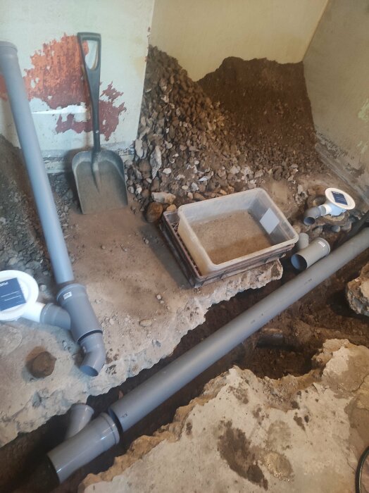 Renovering av tvättstugans avlopp: nya PVC-rör, Y-kopplingar och en gråbrun gjuten golvbrunn.