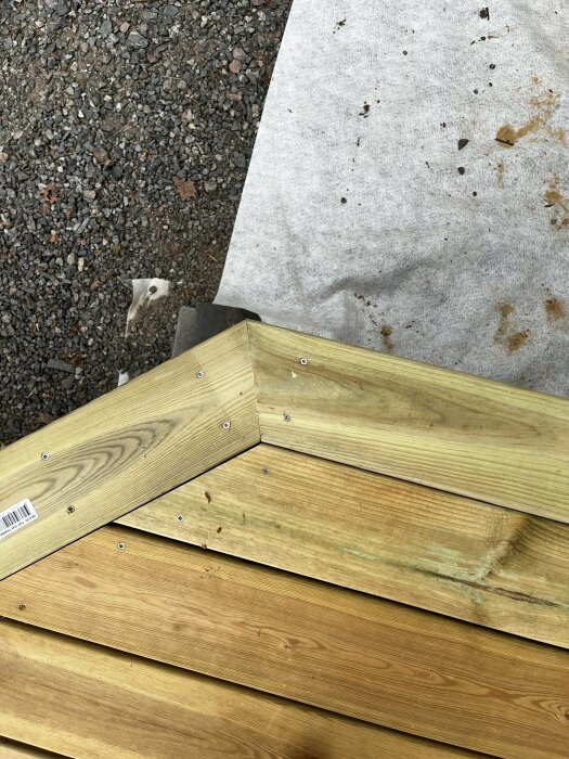 Nysnickrat hörn på trädäck med ordentlig skruvförankring och nyss sammanfogade plank.