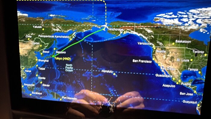 Skärmbild av flygplansmonitor som visar flygsträckan över Stilla havet från Tokyo till Honolulu.