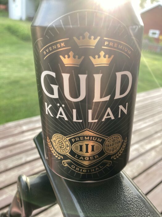 Flaska med svensk premium lager öl på ett trädgårdsbord, utomhus i solljus.