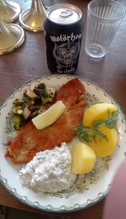 Panerad flundra med remouladsås och kokt potatis, brevid en burk alkoholfri Motörhead-öl.