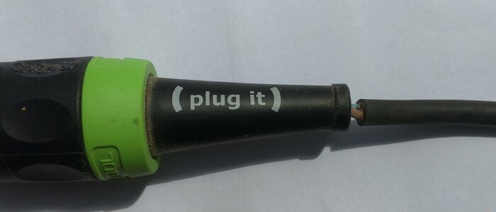 Skadad elektrisk sladd och kontaktdel märkt "plug it" med bar ledning synlig vid brottstället.