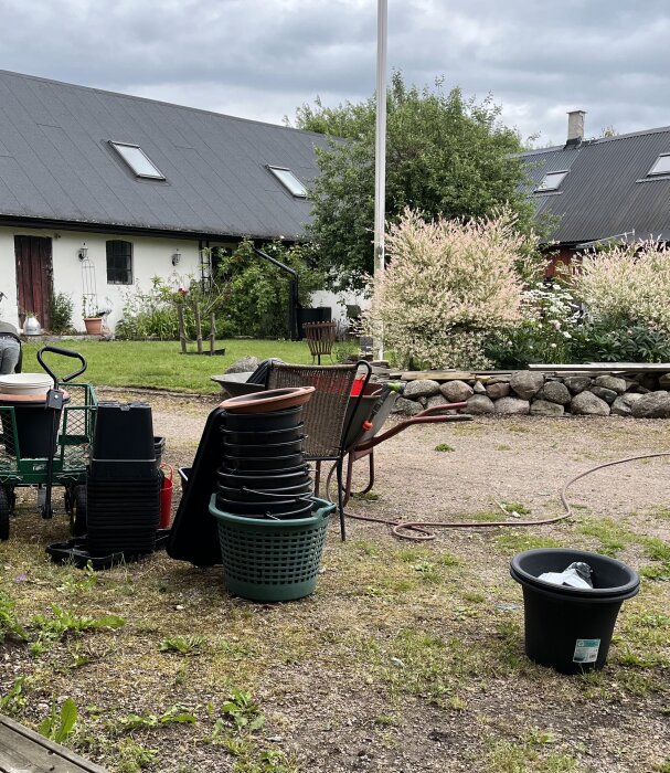 Staplar av rengjorda hinkar och krukor sorterade i storlek på en gräsmatta, redo för plantering.