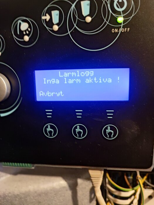 Panel av värmepump med skärm som visar "Inga larm aktiva!" och knappar runtom.