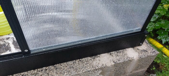 Installation av kanalplastskiva i växthus med grå plastlist i S-form på plåtprofil och spårade aluprofiler.