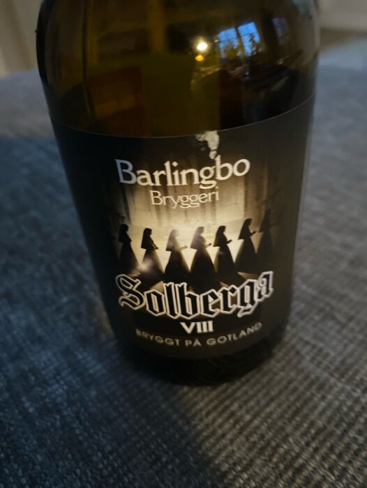 Flaska av Barlingbo Bryggeri Solberga VIII öl, bryggt på Gotland, mot suddig bakgrund.