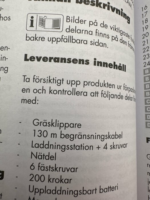 Närbild av en bruksanvisning som listar innehållet i en leverans inklusive gräsklippare och 130m begränsningskabel.