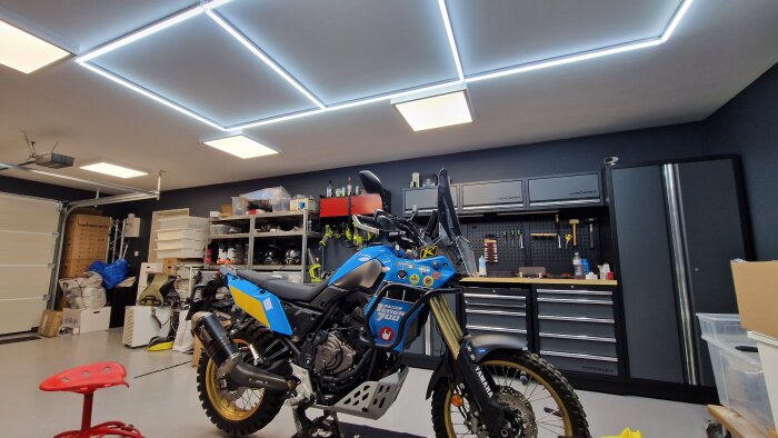 Välorganiserat garage med motorcykel, verktygsskåp, hyllor och LED-takbelysning.