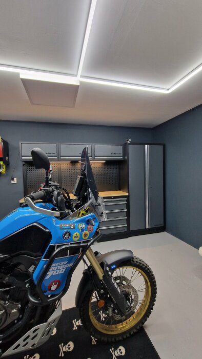 En nyinredd garageinteriör med Homeworx-skåp och en motorcykel framför.