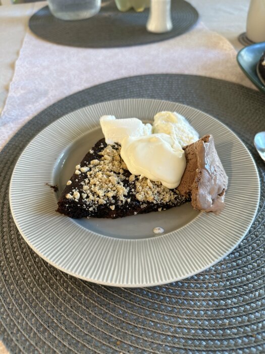 Kladdkaka med glass och strössel serverad på grå tallrik, efterrätt efter en resa.