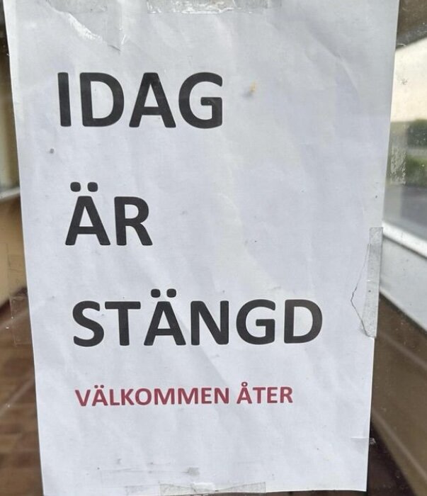 Skylt på fönster med texten "IDAG ÄR STÄNGD VÄLKOMMEN ÅTER" med små felstavningar.